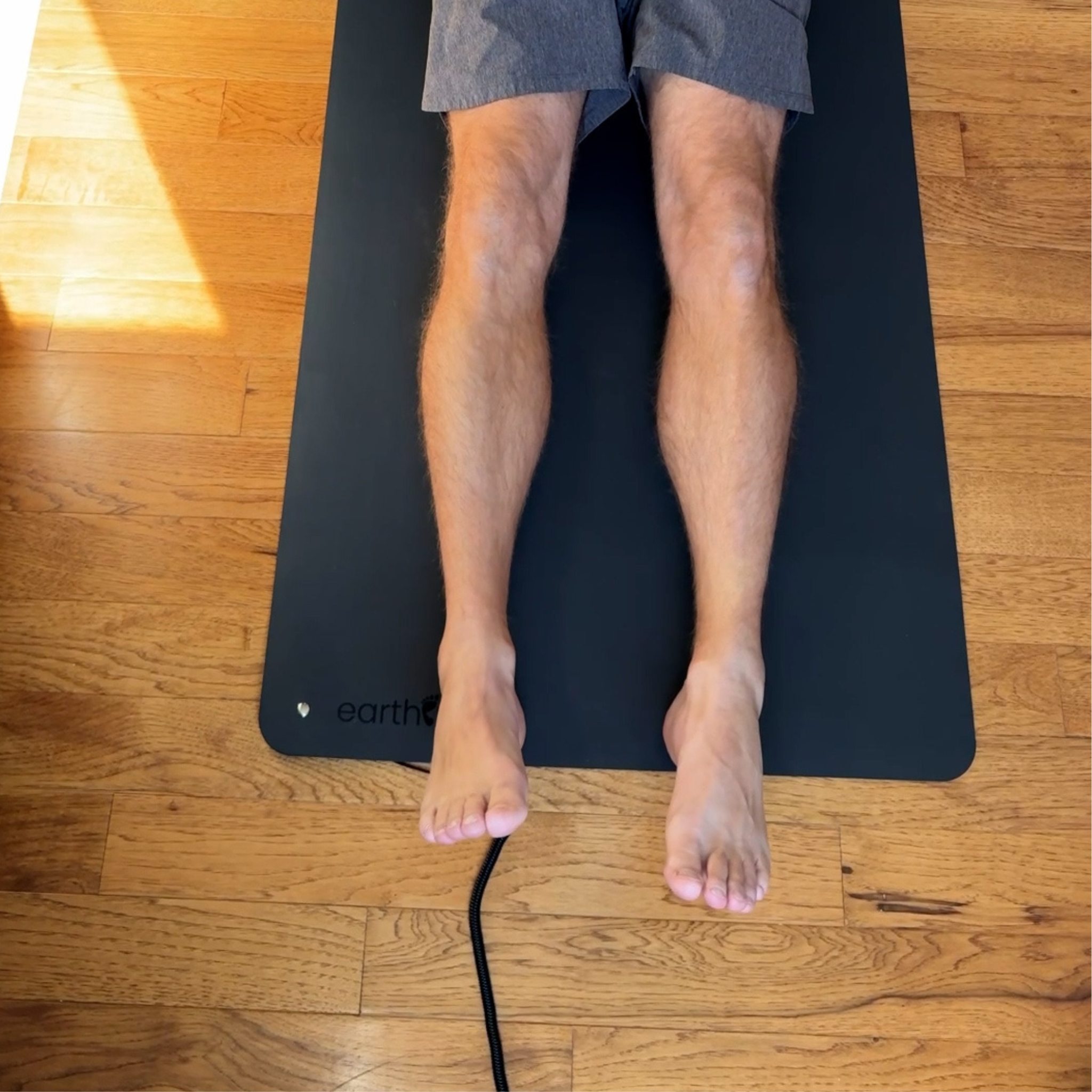 Brad Lying On The Earthing Single Sided Grounded Yoga Mat.Png